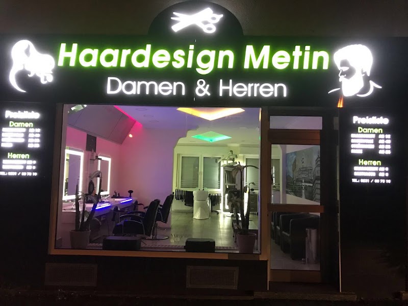 Schaufenster von Haardesign Metin bei Nacht mit Blick auf das beleuchtete Salon-Interieur
